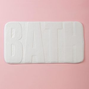 White bathroom mat with lettering