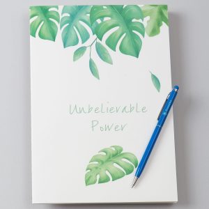 White notebook in exotic leaves