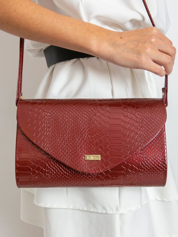 Burgundy clutch bag with snake skin motif